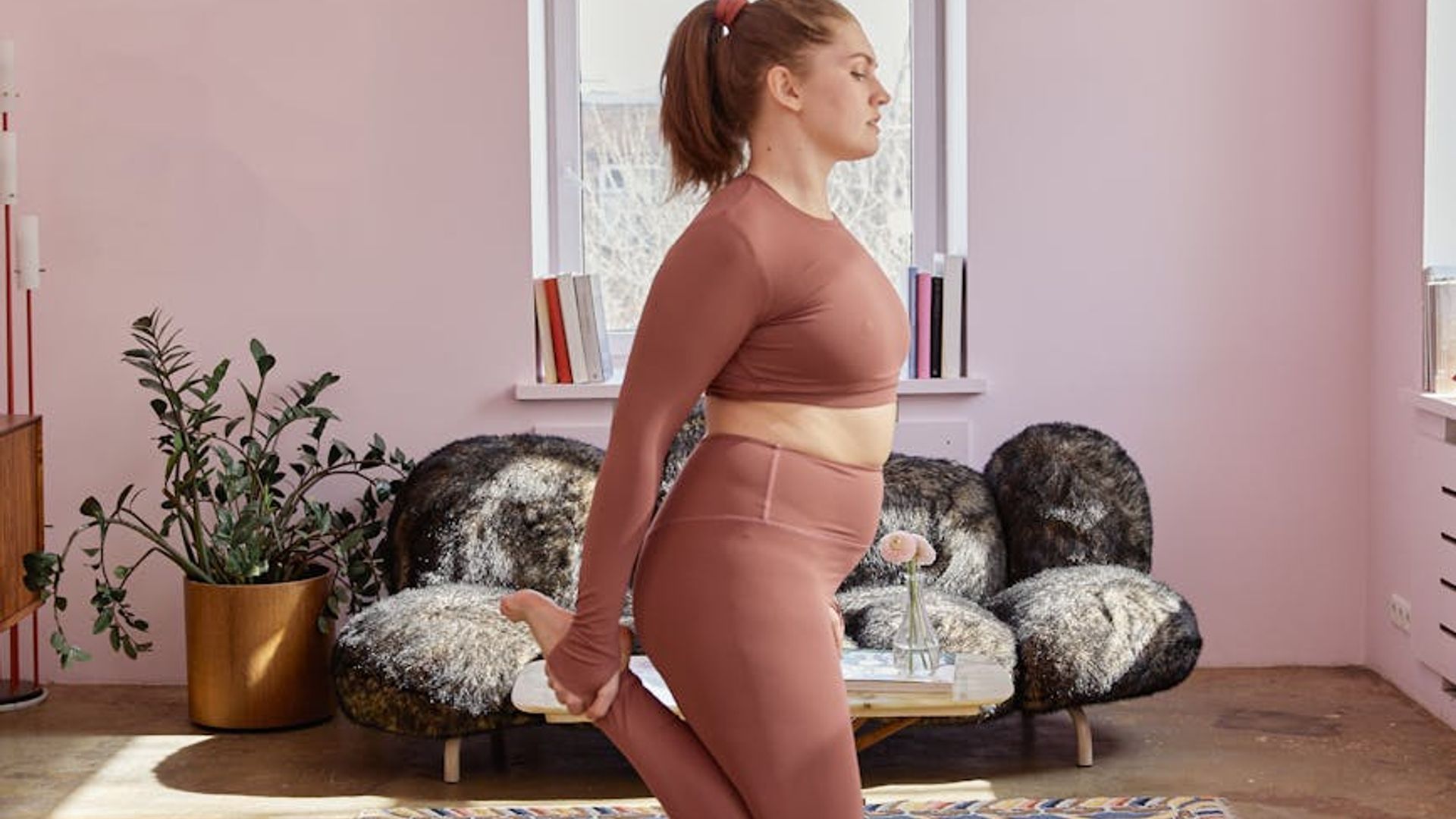 Calm and focused person practicing yoga in a dark, minimalist room.